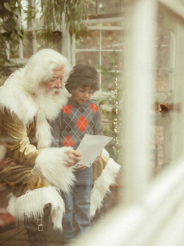 A little boy shares his Christmas list with The Singing Santa of Atlanta at Das Hinterhaus in Marietta, GA. 