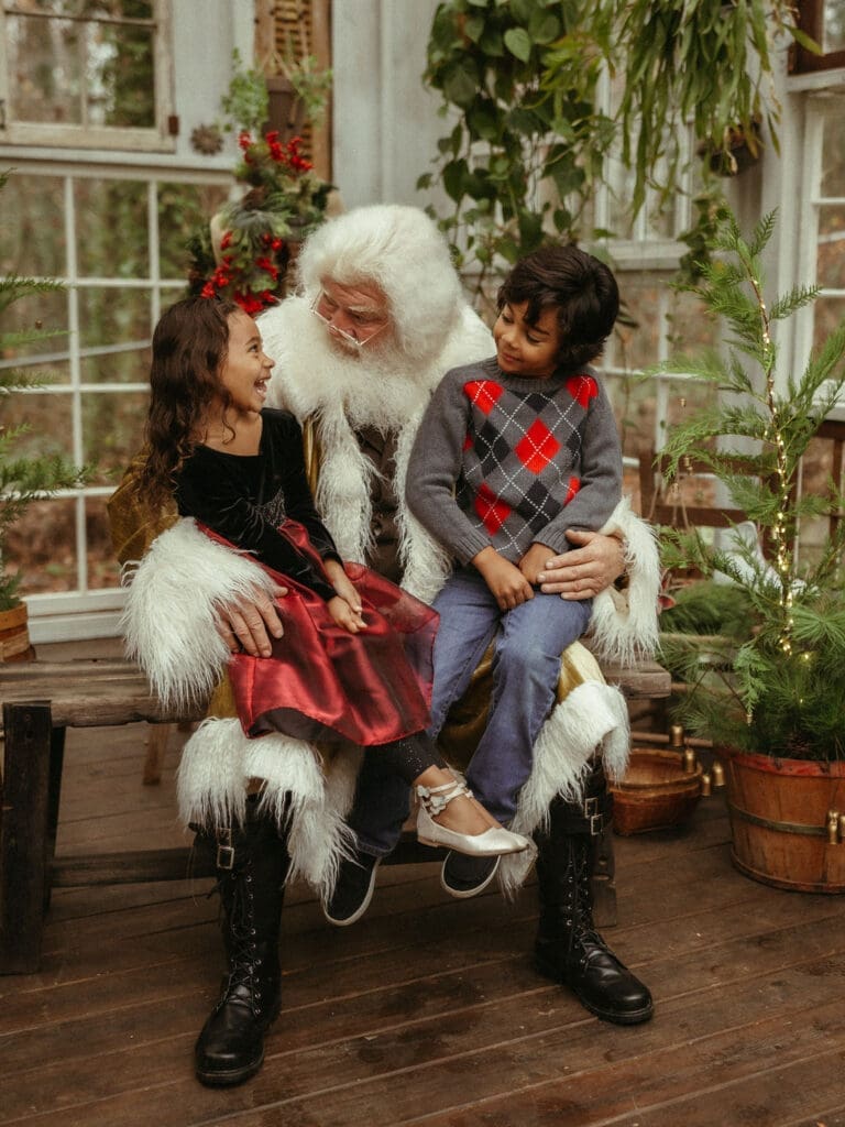 Two young kids sit in groovy Santa's lap at Das Hinterhaus in Marietta, GA. 