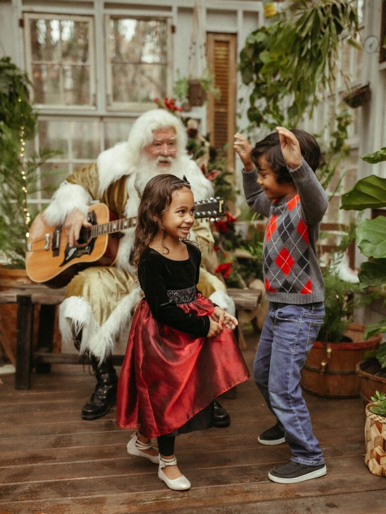 Two kids dance while groovy Santa plays guitar at Das Hinterhaus in Marietta, GA. 