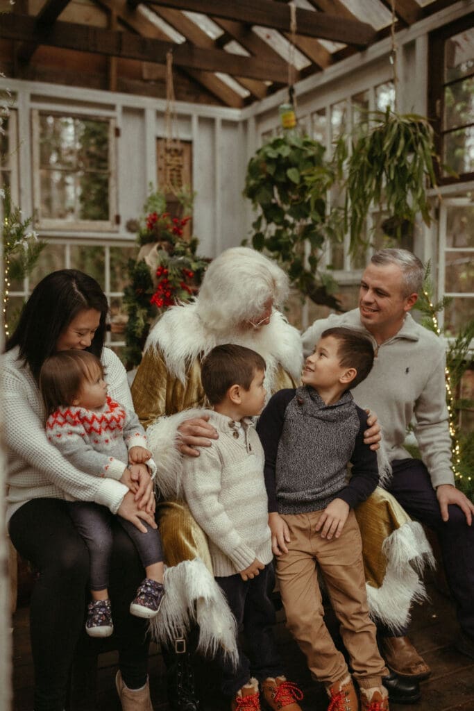 A family sitting with The Singing Santa of Atlanta at Das Hinterhaus in Marietta, GA. 