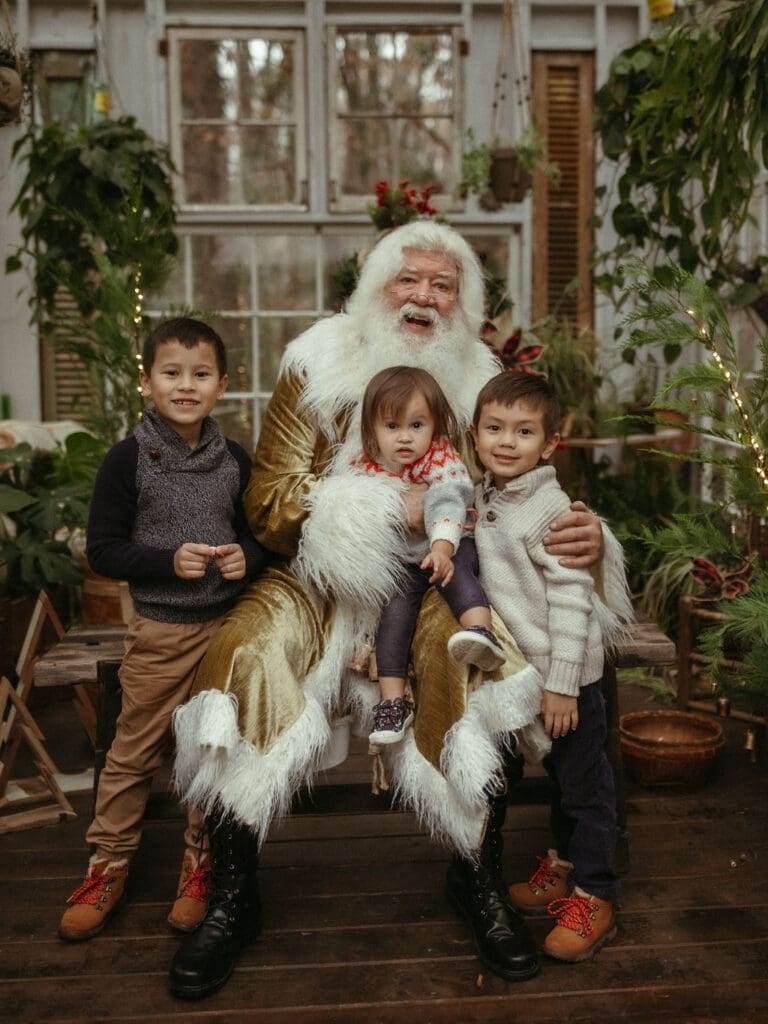 Three siblings sitting with Santa at Das Hinterhaus. 