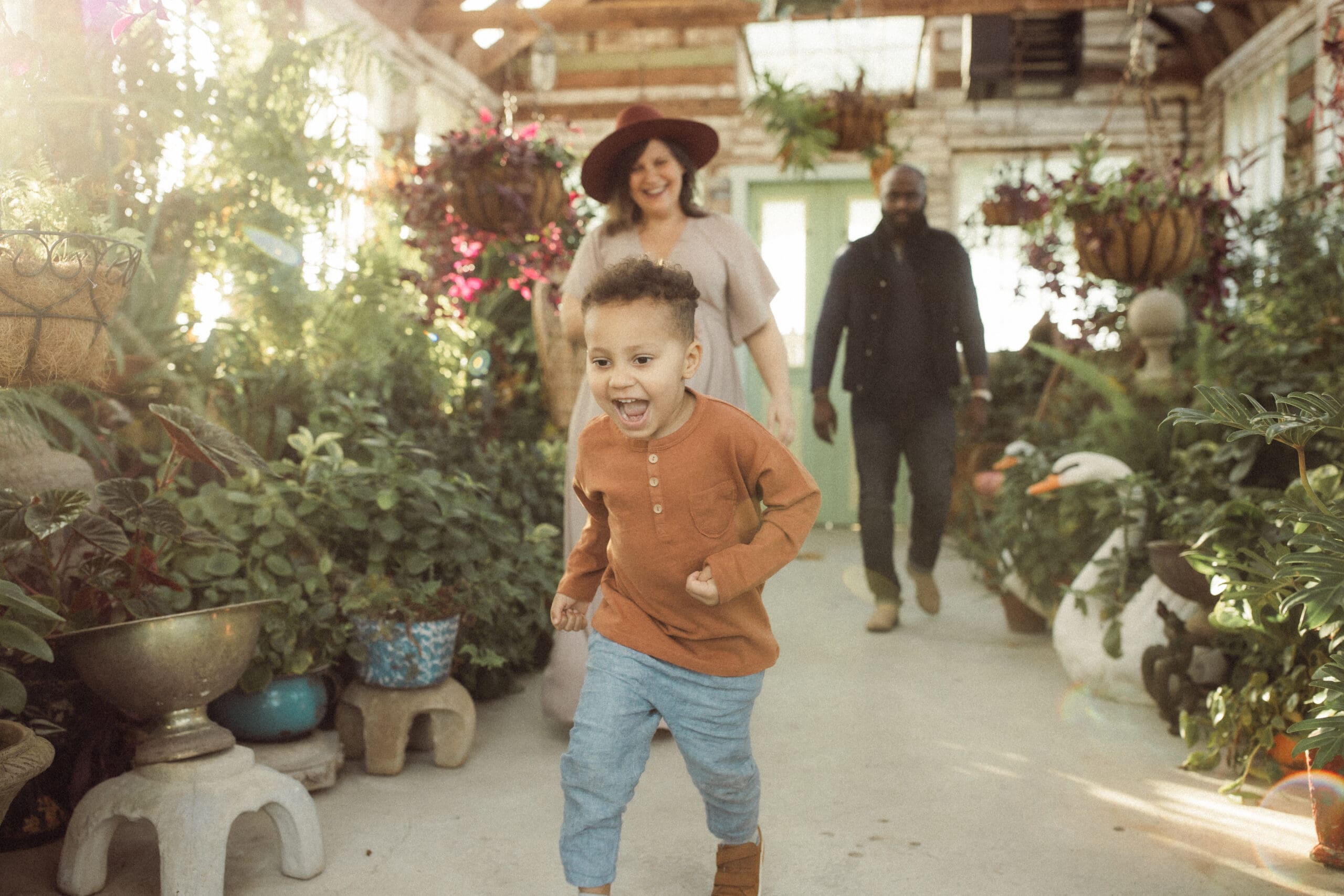 A toddler boy running away from his parents at