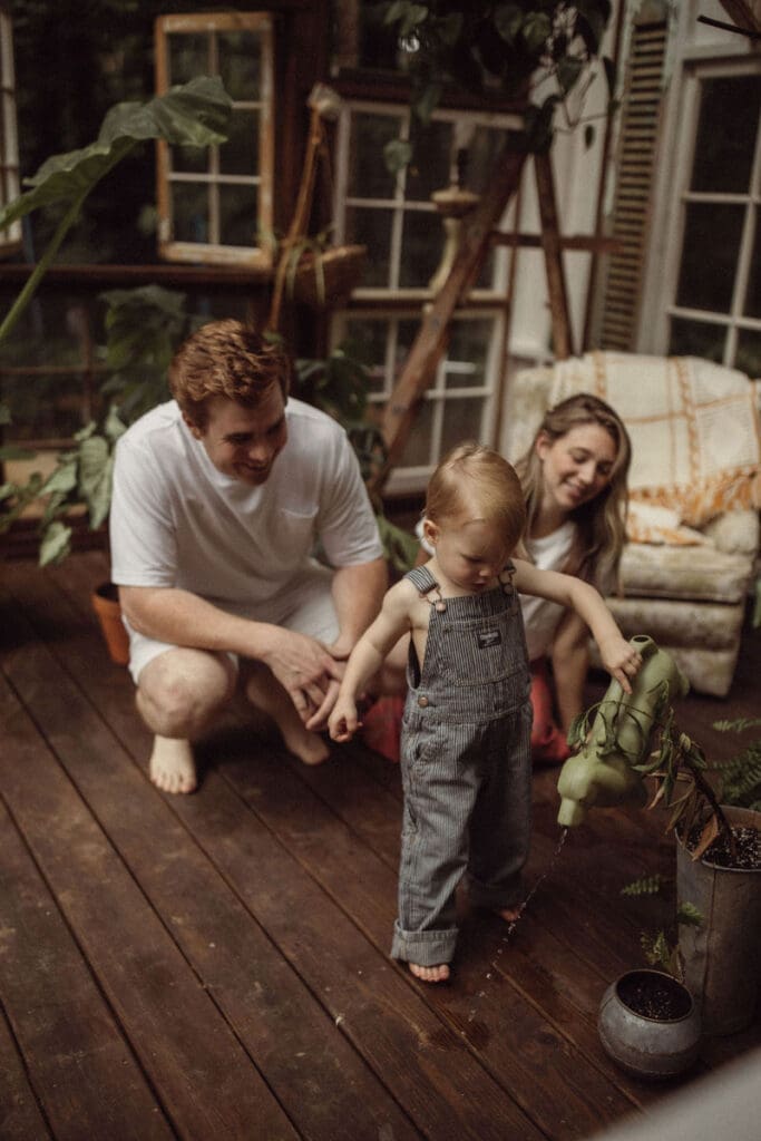 A family playing with the watering can at Das Hinterhaus in Marietta, GA. 