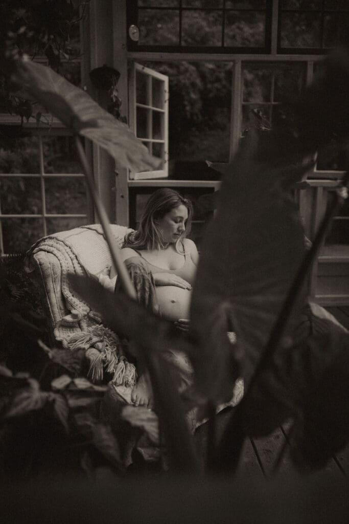 A pregnant mom sitting in a chair inside Das Hinterhaus. 