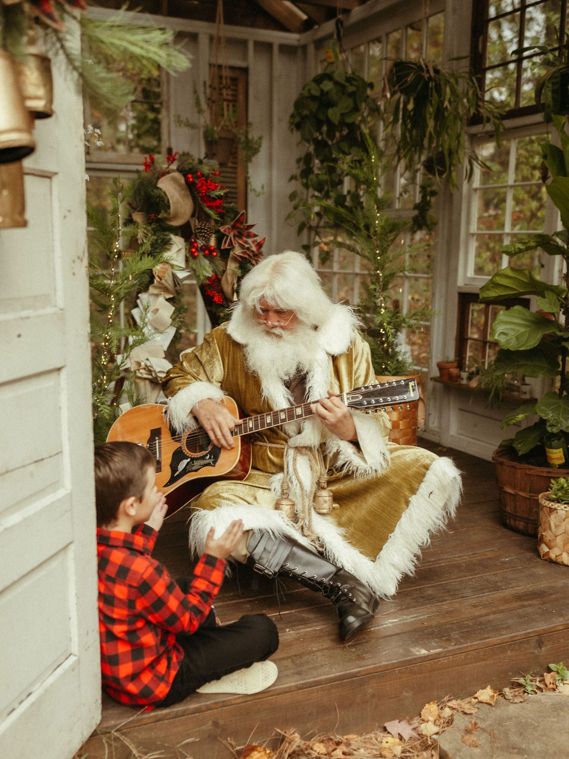 The Singing Santa of Atlanta strumming the guitar for a young boy at Das Hinterhaus Studio in Marietta, GA.