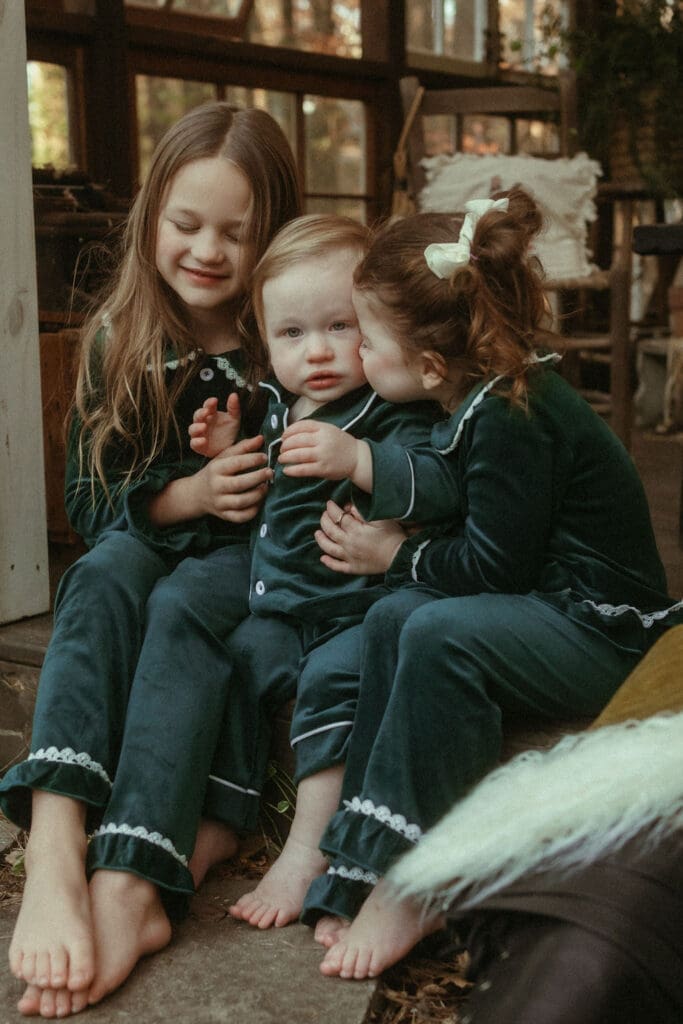 Two big sisters love on their little baby brother at Das Hinterhaus Studio in Marietta, GA. 