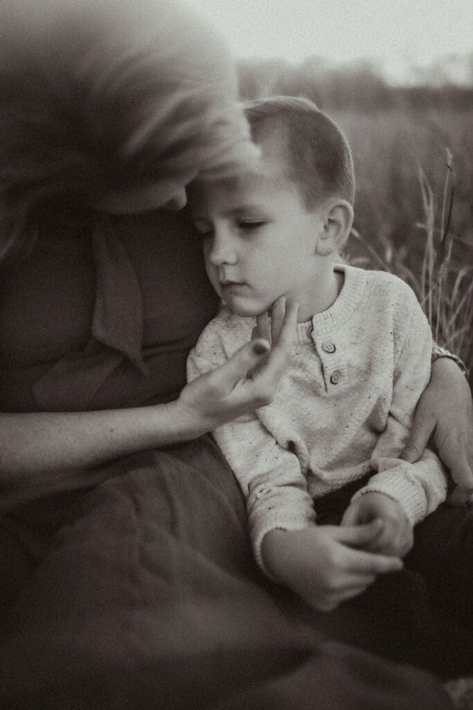 A mother cupping the face of her son. 