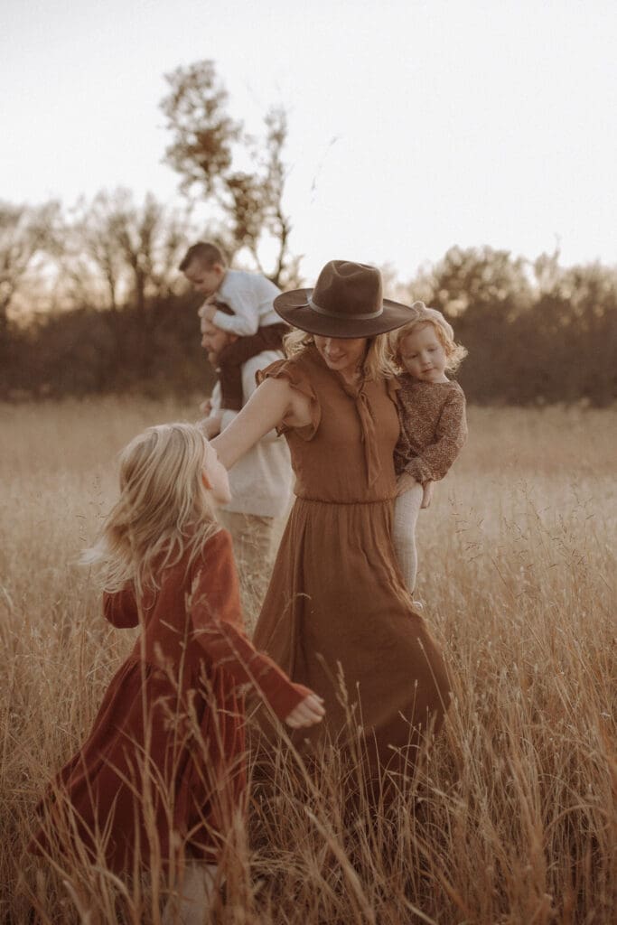 A family of five playing in a field together. 