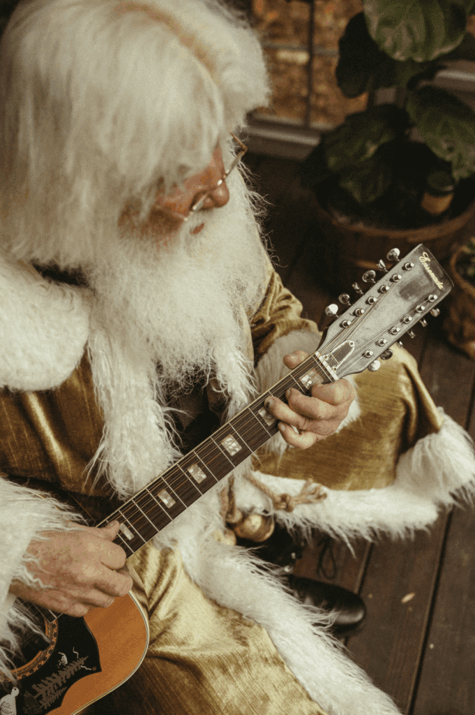 Groovey Santa of Atlanta strumming the guitar. 