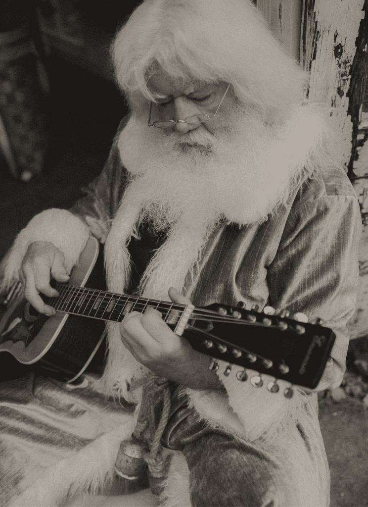 Hippie Santa strumming his guitar.
