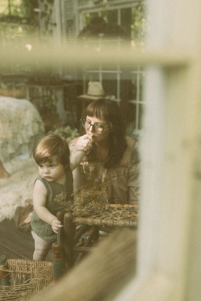 Mother snuggling her children during an unposed greenhouse family photography session