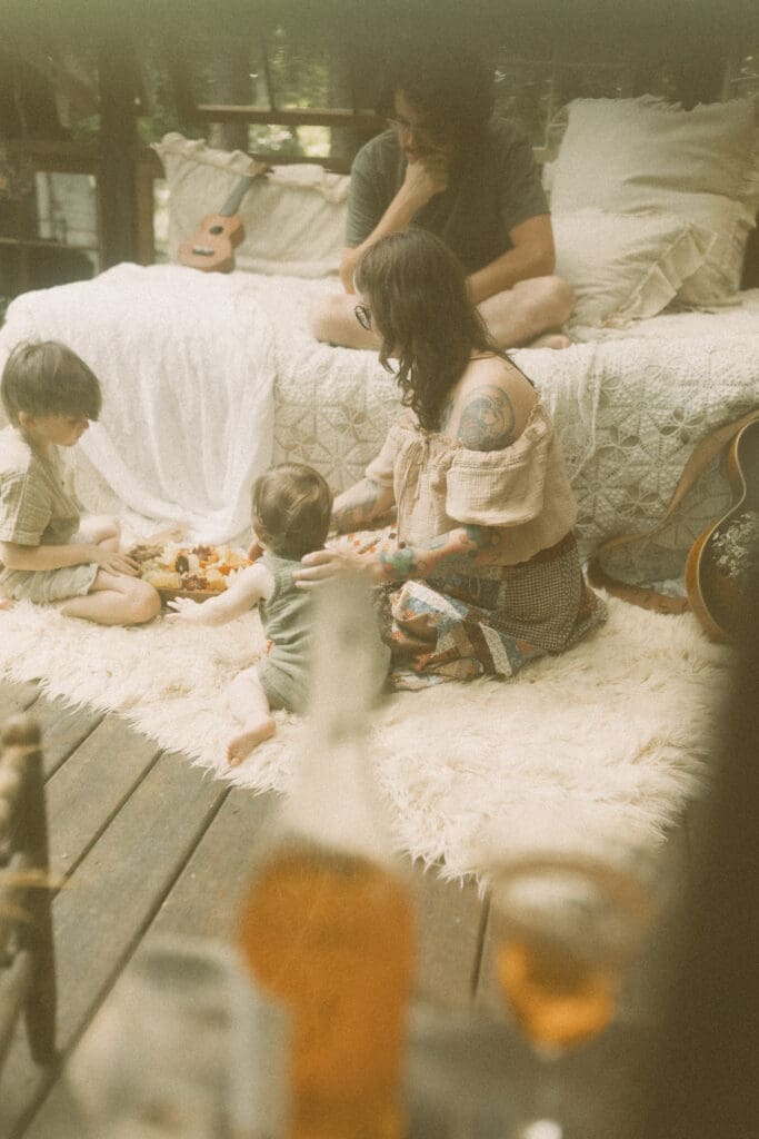 Mother snuggling her children during an unposed greenhouse family photography session