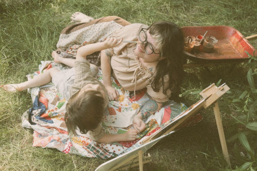 Unposed family photography capturing children creating art inside a sunlit greenhouse