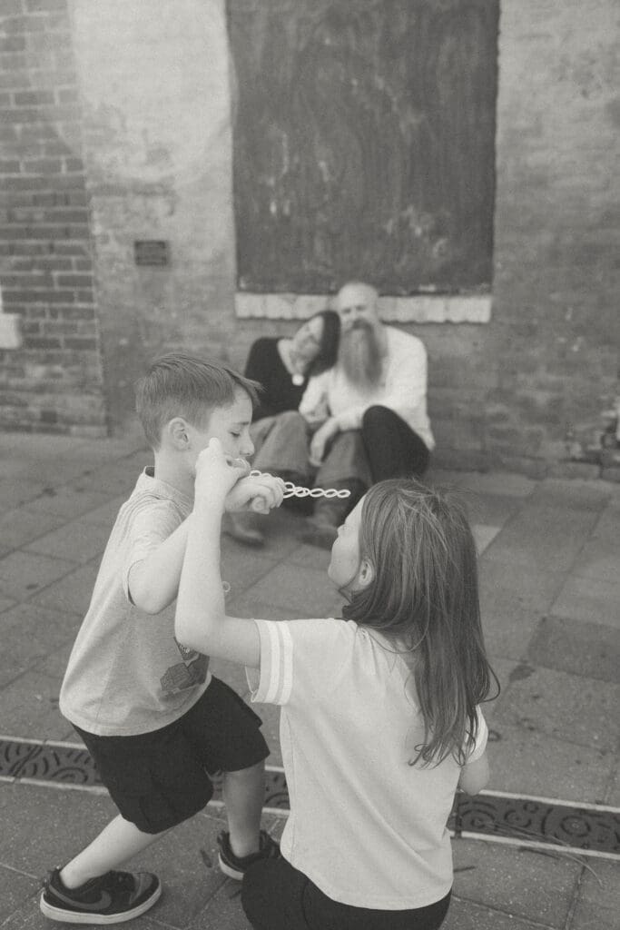 kids blow bubbles while mom and dad rest against the wall- acworth, ga