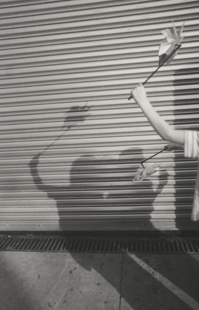 kids make their pinwheel shadows on a metal garage door