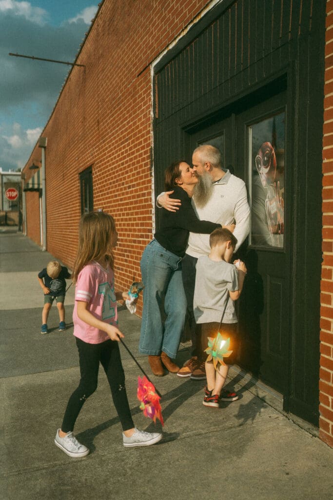 mom and dad still kissing while all the kids play around them. Still have the alien in the shot